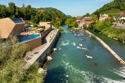 Das Wellness-Therme FORTYSEVEN in Baden (5400, Kanton Aargau) liegt direkt an der Limmat und fügt sich harmonisch in die grüne Umgebung.