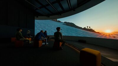 Im Besucherzentrum Welterbe Swiss Alps Jungfrau-Aletsch in Naters (3904, Kanton Wallis) sehen Besucher eine Projektion mit Berglandschaft und Sonnenaufgang.