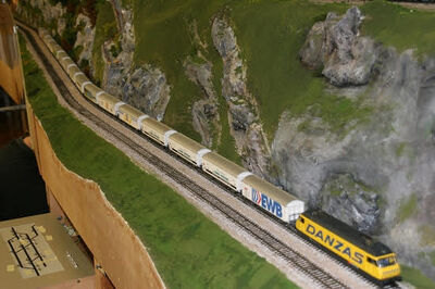 Eine detailreiche Modelleisenbahnanlage ist in Buchs (9470, Kanton St Gallen) mit Gueterzug, Tunnelstrecke und felsiger Landschaft aufgebaut.
