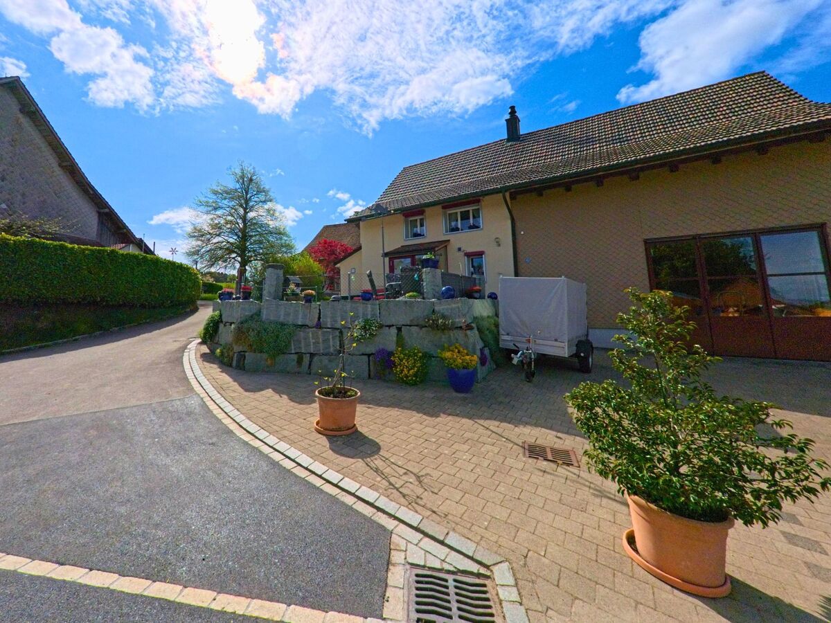 In Wiesendangen (8543, Kanton Zürich) sieht man ein gepflegtes Einfamilienhaus mit einem schönen Garten und einer Steinmauer, die das Grundstück umrahmt.