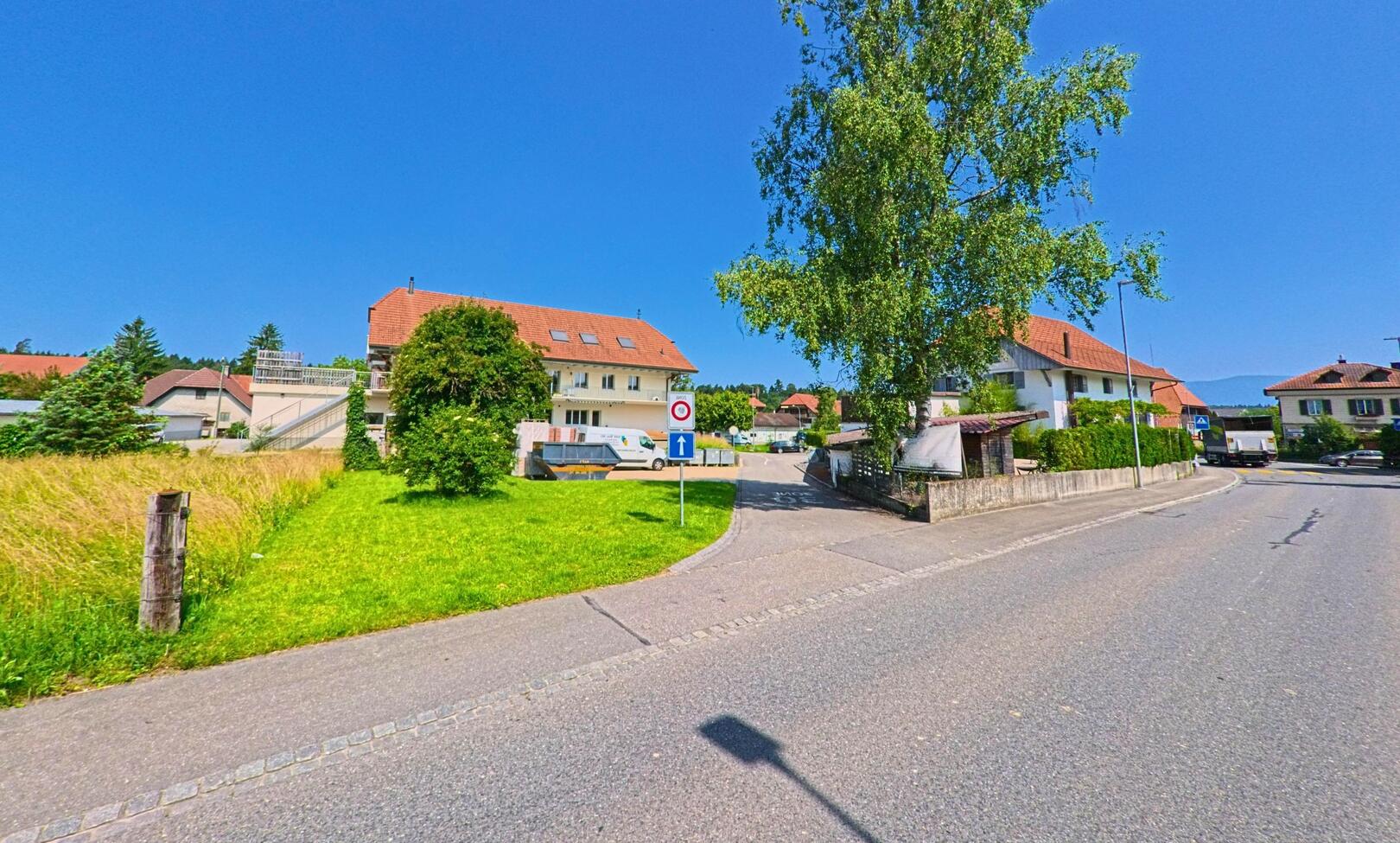 In Wiler bei Utzenstorf (3428, Kanton Bern) zweigt bei einem Verkehrsschild ein schmaler Strassenabschnitt zwischen Einfamilienhäusern in eine ruhige Seitenstrasse ab.