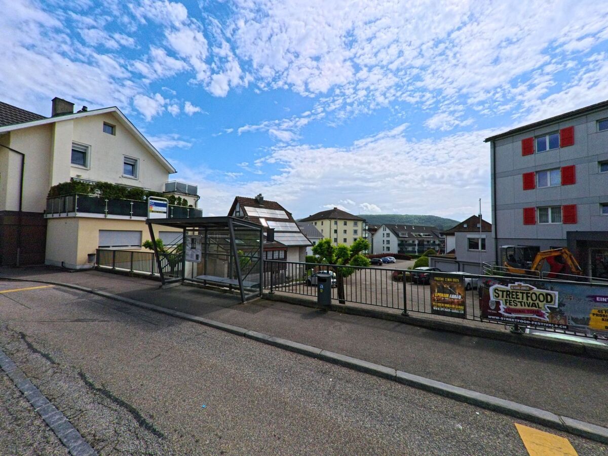 Im Zentrum von Winznau (4652, Kanton Solothurn) befindet sich eine Bushaltestelle vor Wohnhäusern, mit Plakaten für ein Streetfood Festival am Geländer.