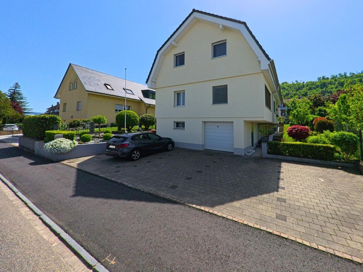 In Witterswil (4108, Kanton Solothurn) liegen moderne Einfamilienhäuser mit gepflegten Vorgärten entlang einer ruhigen Anwohnerstrasse.