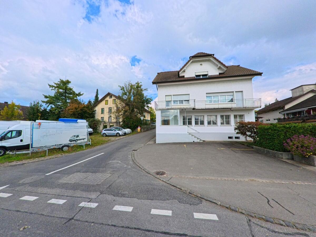 In Zetzwil (5732, Kanton Aargau) steht ein grosszuegiges weisses Haus mit breiter Auffahrt und Balkonfront an einer ruhigen Strassenabzweigung.