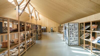 Im Ziegelei-Museum in Hagendorn (6332, Kanton Zug) zeigt eine helle Ausstellungshalle mit Holzdach und Regalen verschiedene Ziegel, Werkzeuge und historische Objekte.