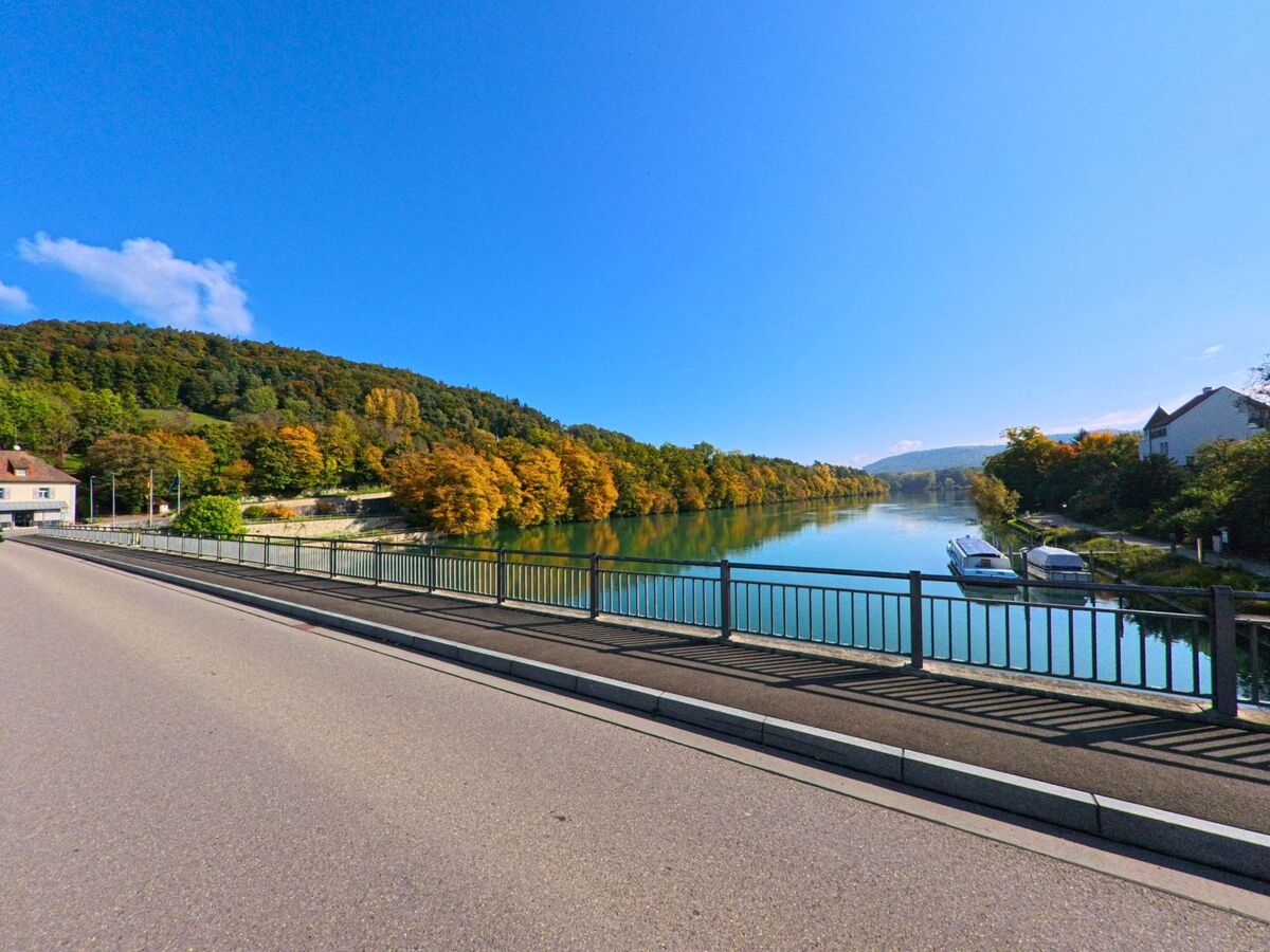 Von einer Bruecke in Zurzach (5466, Kanton Aargau) bietet sich ein weiter Blick ueber den ruhigen Rhein und die herbstlich gefaerbten Uferhaenge.